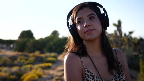 Una-Hermosa-Mujer-Hispana-Escuchando-Música-En-Sus-Auriculares-Y-Sonriendo-Con-Felicidad-Al-Aire-Libre-En-Cámara-Lenta-Natural