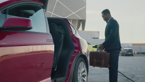 hombre cargando un coche eléctrico