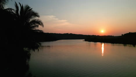 Drone-shot-of-dramatic-sunset-sky-with-clouds,-over-river-south-Goa,-India-4K