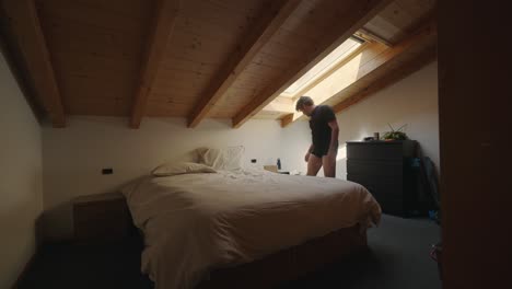 man opening the tent of the velux wooden rooftop window