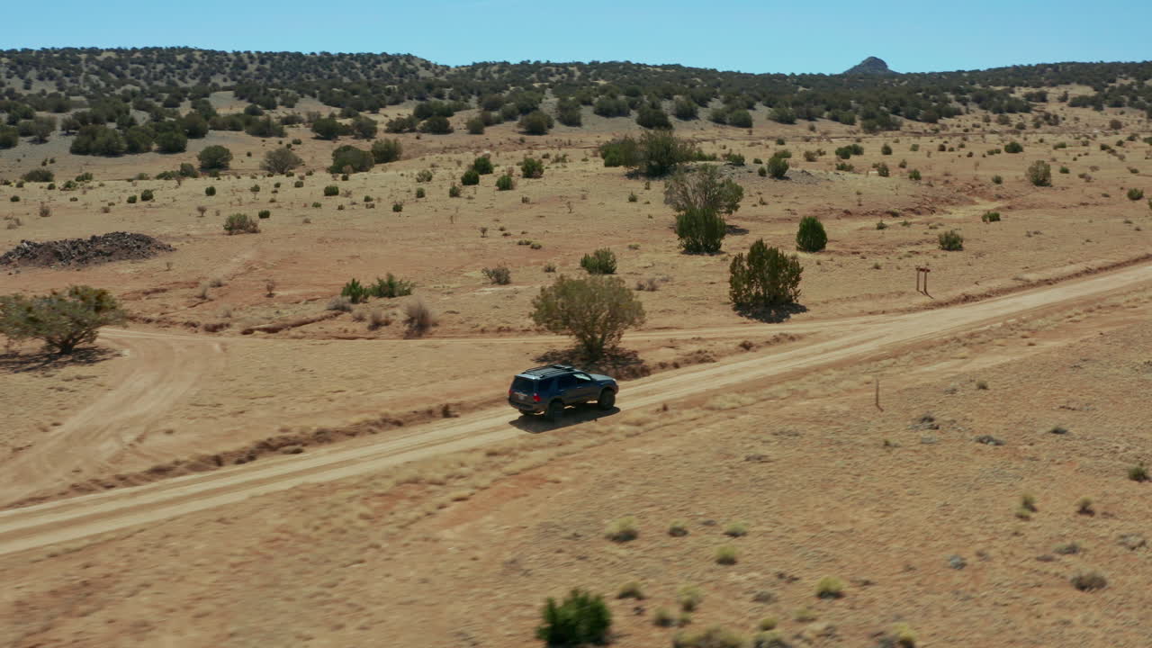 사막 풍경의 비포장 도로에서 4x4 suv를 따라가는 공중 패닝