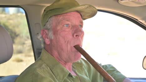 closeup portrait older man smoking huge cigar inside car while driving