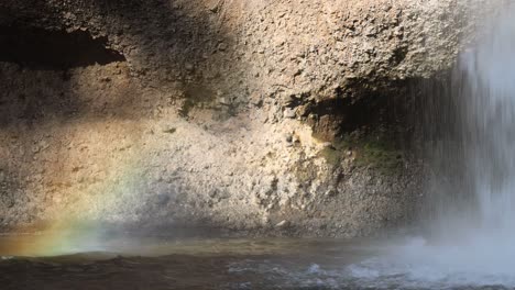 water cascading down rocks creating a rainbow