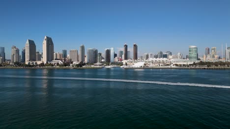 una lancha rápida navegando en la bahía a lo largo del horizonte del centro de san diego en san diego, california