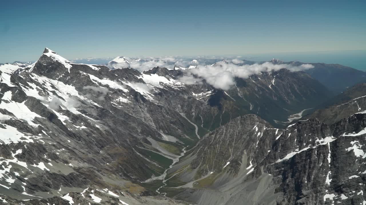toma aérea desde un vuelo panorámico sobre la costa oeste glaciar franz josef monte cook aoraki, parque nacional con nubes, montañas rocosas nevadas y océano en el fondo