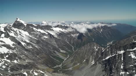 Toma-Aérea-Desde-Un-Vuelo-Panorámico-Sobre-La-Costa-Oeste-Glaciar-Franz-Josef-Monte-Cook-Aoraki,-Parque-Nacional-Con-Nubes,-Montañas-Rocosas-Nevadas-Y-Océano-En-El-Fondo