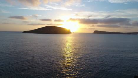 Toma-Aérea-De-Amigos-En-Acantilados-Viendo-La-Puesta-De-Sol-Sobre-El-Mar