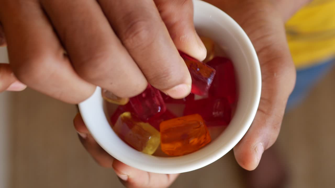 niño sosteniendo un cuenco de caramelos coloridos
