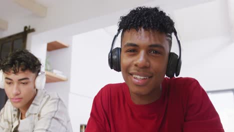 portrait of happy diverse male teenage friends having video call at home, slow motion