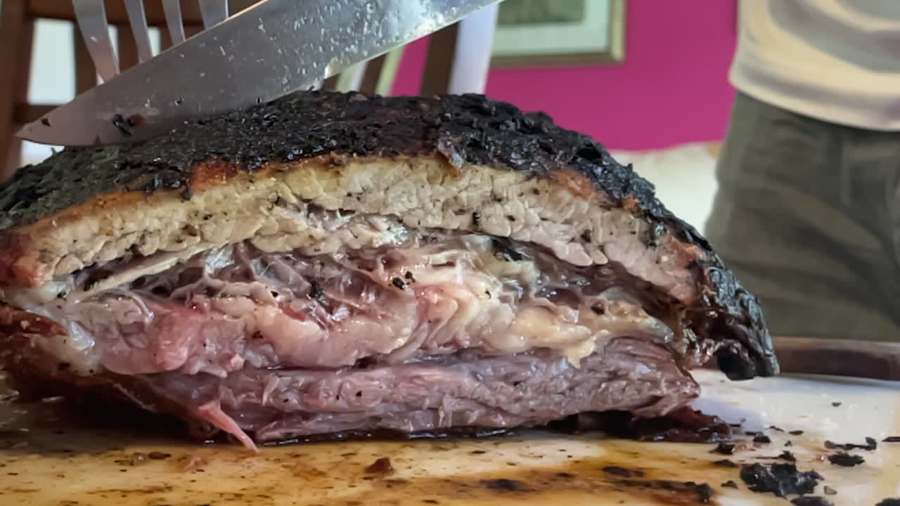 escena en cámara lenta de un corte de carne fina siendo cortada por un cuchillo