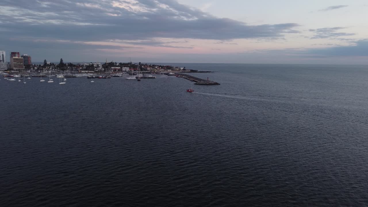 vista cinematográfica del barco de pesca en el vasto océano, acercándose al puerto de la ciudad de punta del este
