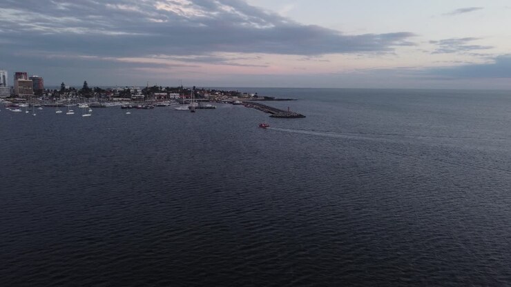 Veduta cinematografica di un peschereccio in vasto oceano, in avvicinamento al porto della città di Punta del Este