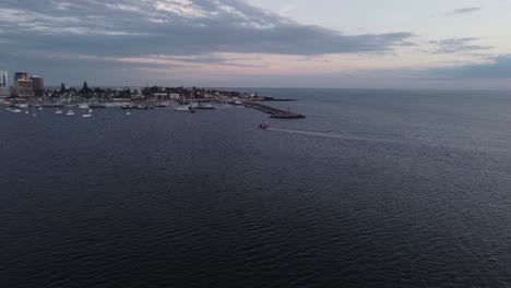 Filmischer-Blick-Auf-Ein-Fischerboot-Im-Weiten-Ozean,-Das-Sich-Dem-Hafen-Der-Stadt-Punta-Del-Este-Nähert