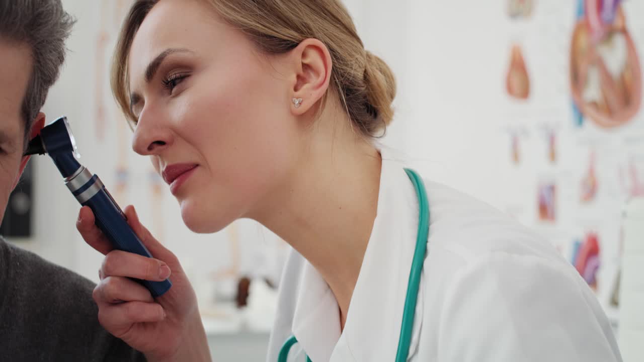 video de mano muestra a un médico examinando la oreja de un hombre mayor