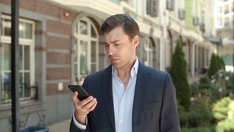 closeup man using modern phone at street. businessman typing number outdoor