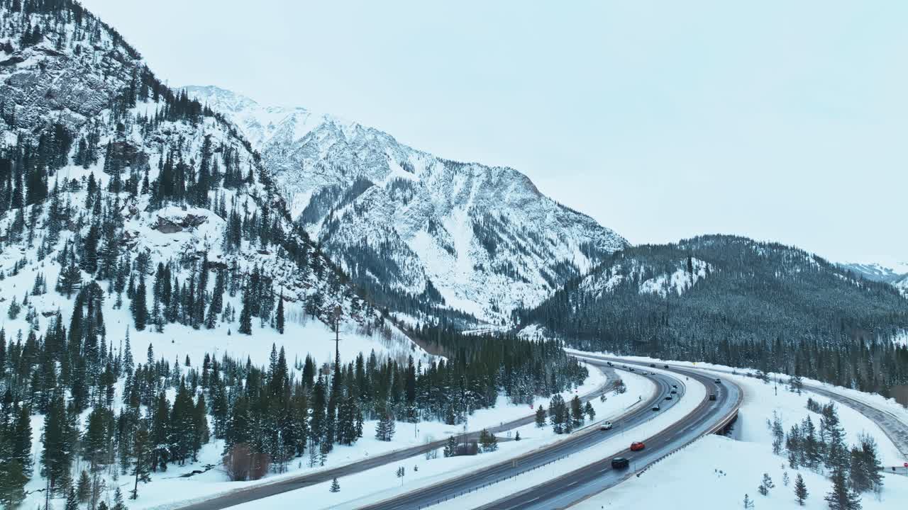 Aerial establishing of snow covered highway winding through evergreen forests between Frisco and Silverthorne, Colorado