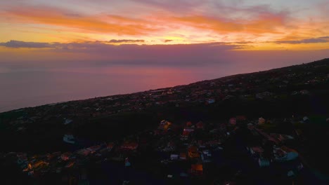 fotografía aérea al revés de una aldea portuguesa en una colina con vista al océano atlántico durante la puesta de sol en la isla de madeira