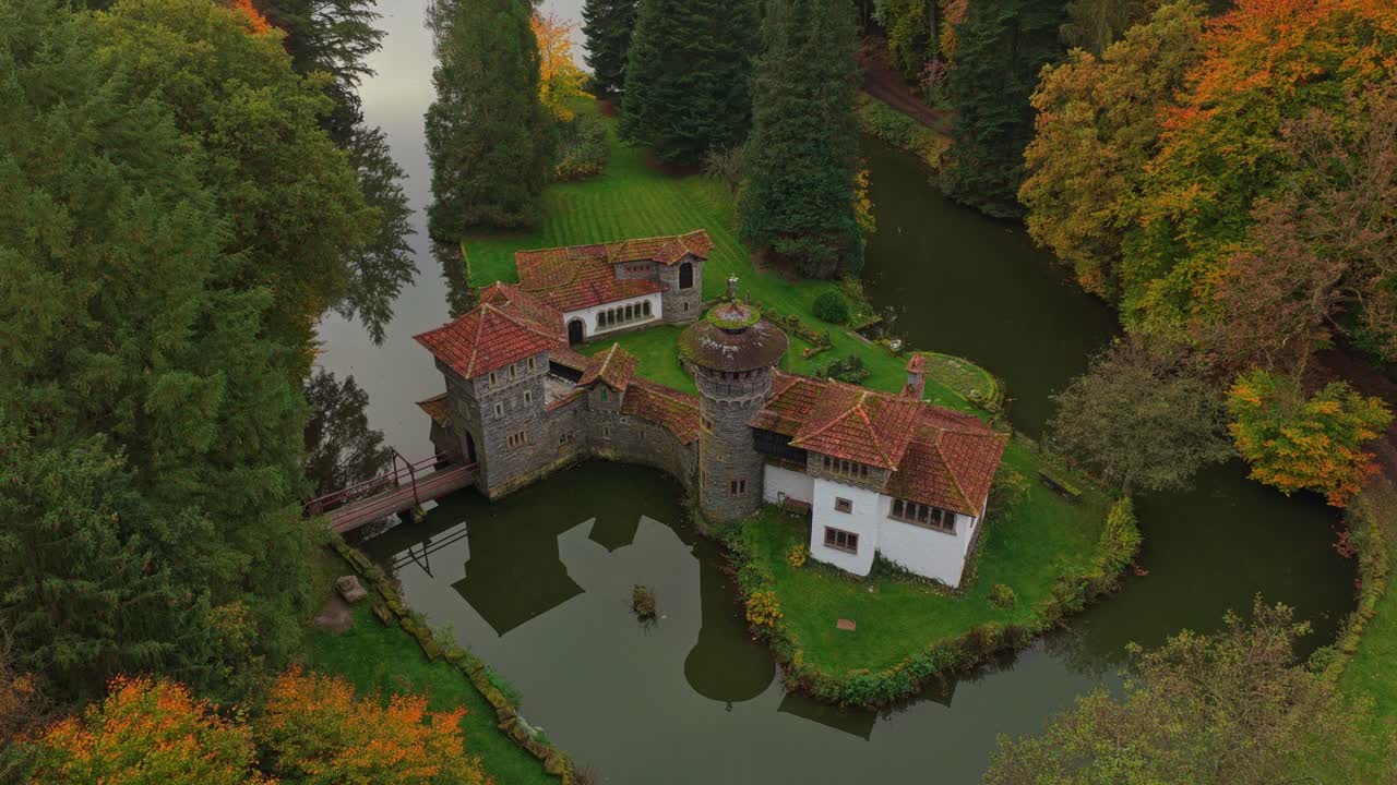 Droneudsigt af Chateau de Turelbaach omgivet af efterårstræer i Luxembourg