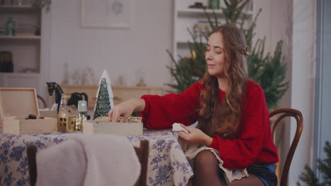 mujer limpiando baubles con tela sentada en la silla