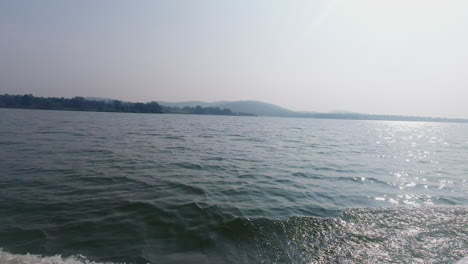 Serene view of Kabini River during an afternoon boat safari showcasing lush greenery