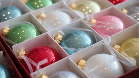 variedad de bolas de árbol de navidad de colores brillantes con un acabado brillante almacenadas en una caja