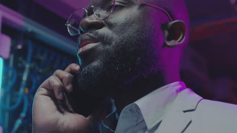 it professional talking on phone in a neon-lit data center