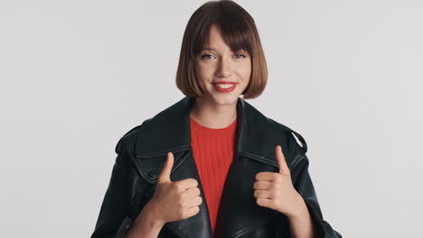 Smiling-girl-giving-thumbs-up-in-studio