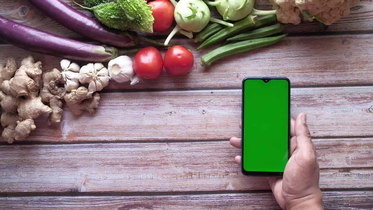 verduras y teléfonos inteligentes en una mesa de madera