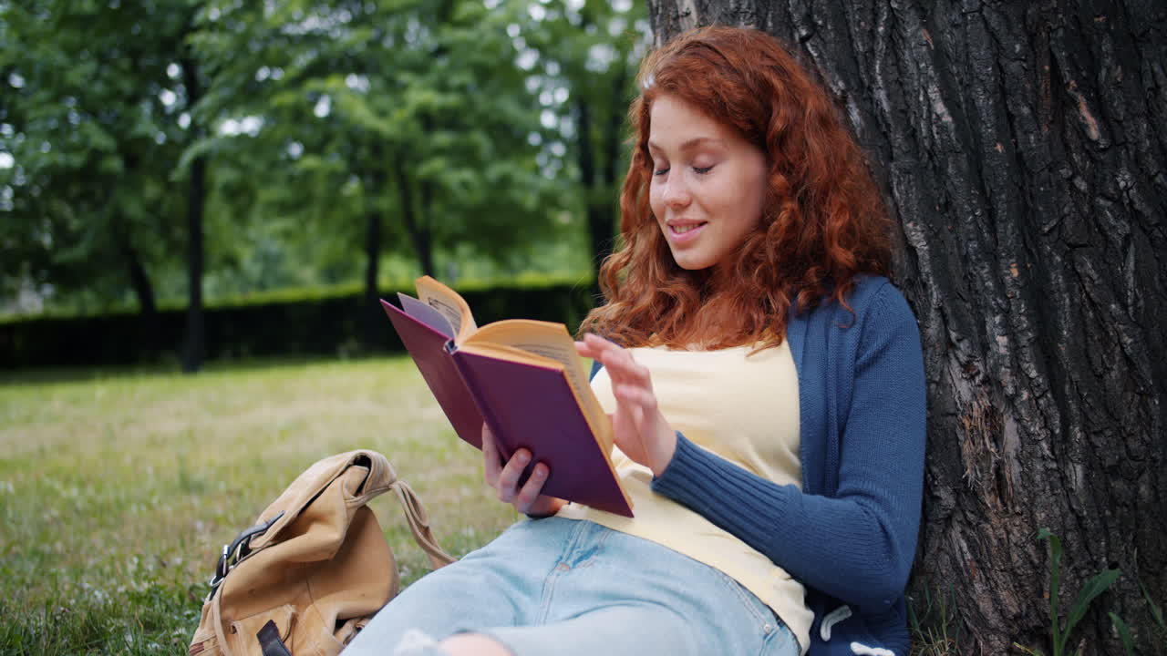 mujer leyendo un libro en un parque