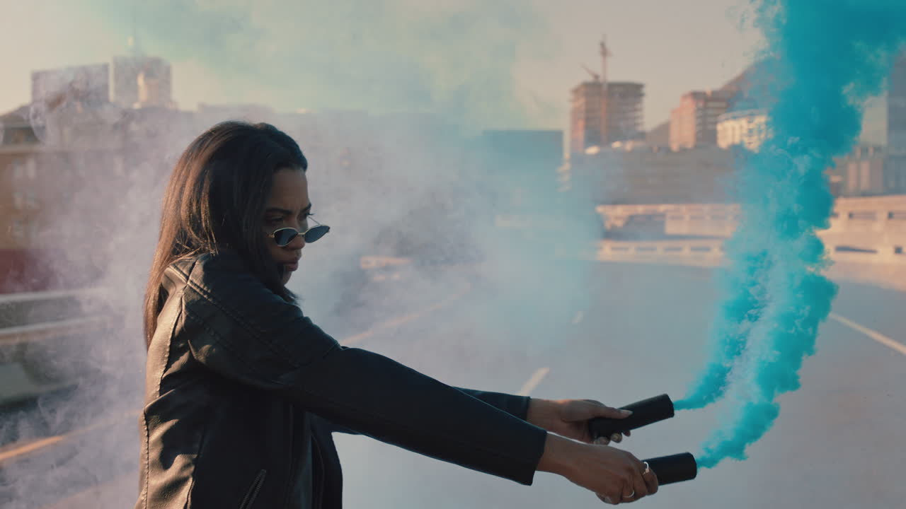 chica bailando con bomba de humo azul en la ciudad joven bailarina celebrando la expresión creativa con el hip hop bailando en la calle en cámara lenta
