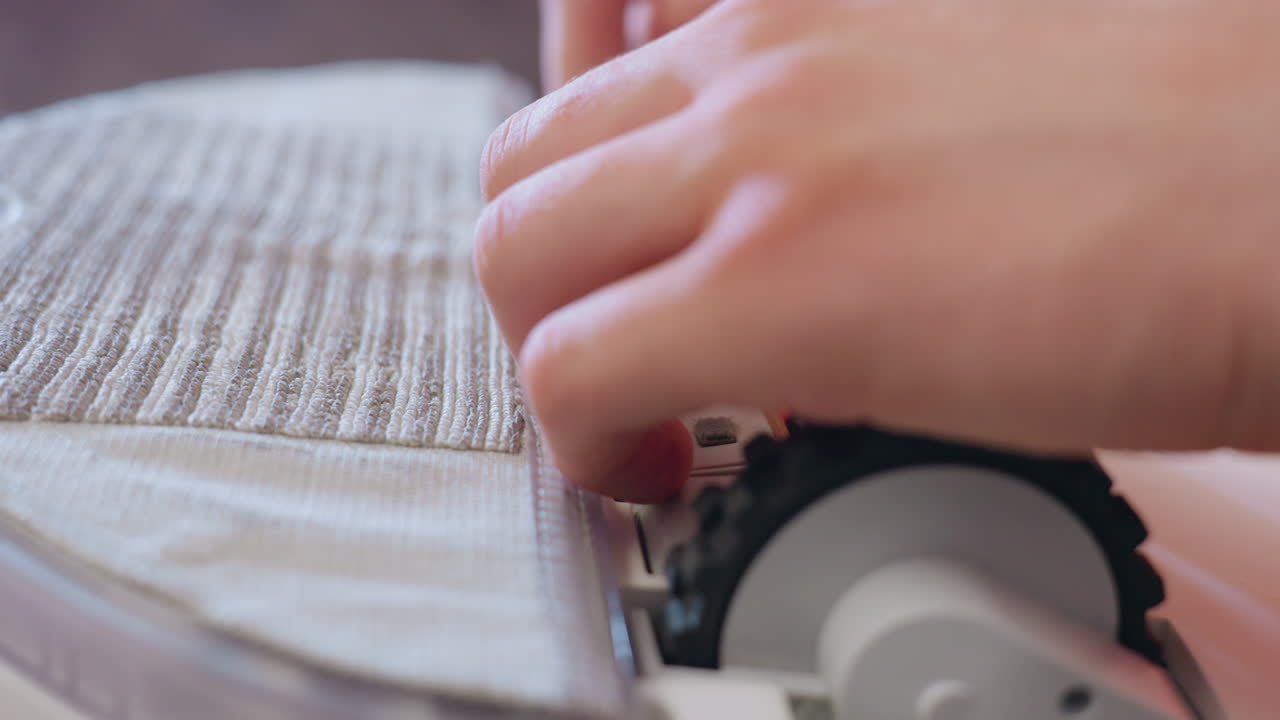 Close up of technician hand repairing vacuum cleaner wheel and brush, adjusting internal parts with precision and care, demonstrating household device maintenance