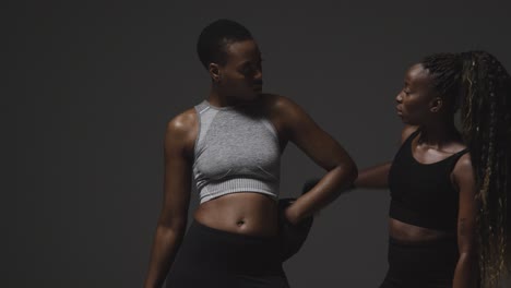 portrait en studio d'une femme portant des gants de boxe s'entraînant avec l'entraîneur 2