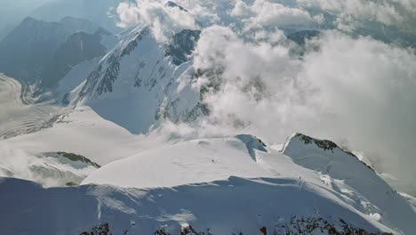 stunning birds eye view,climbers on snow mountain top,great clouds around summit