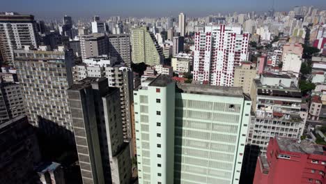 Flying-low-over-vibrant-buildings-of-Sao-Paulo,-sunny-day-in-Brazil---Aerial-view