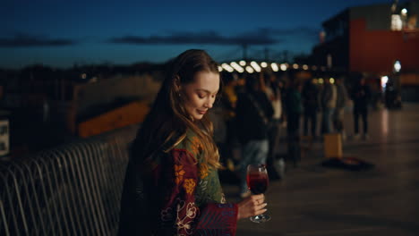 lady enjoy weekend party at evening city street holding cocktail close up.