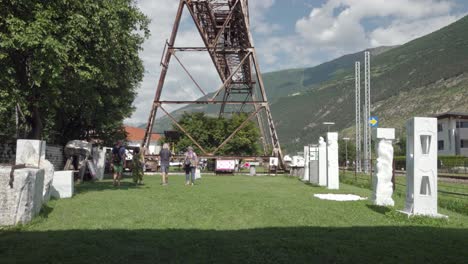 people walking through a sculpture park in the mountains
