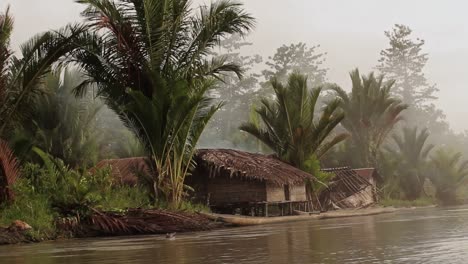 Chozas-Indígenas-En-El-Río-En-La-Selva-En-Papua---Tiro-De-Una-Canoa