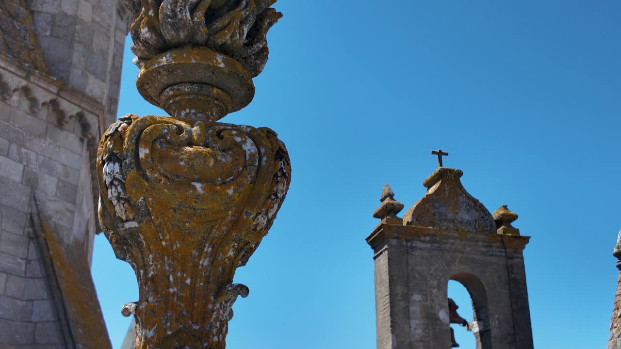 Stone turrets and aged bell tower with lichen textures under clear sky portugal