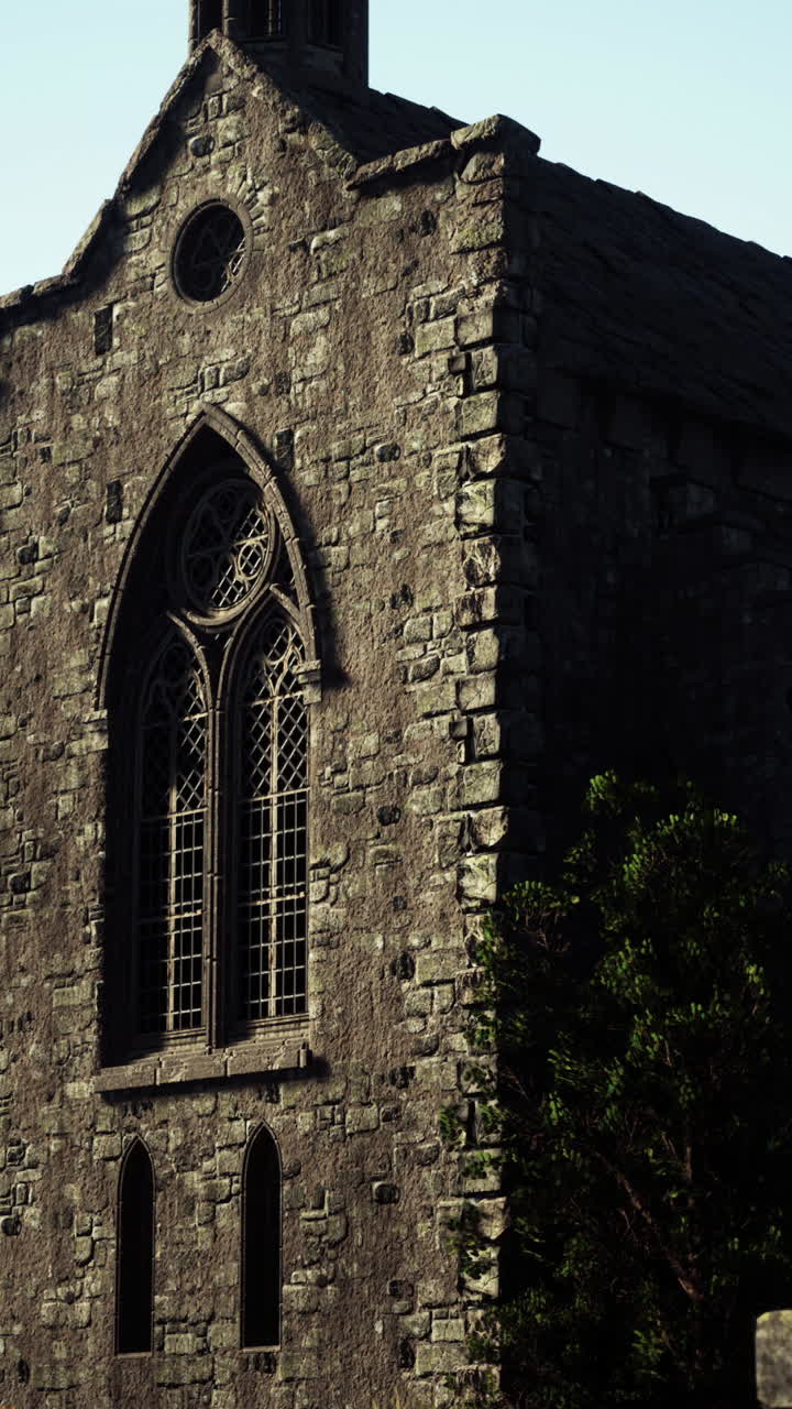 고 양식의 창문이 있는 돌로 된 교회 외관의 클로즈업