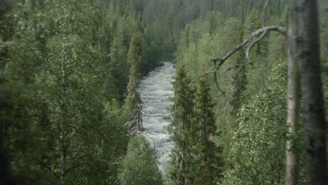 beautiful wide shot of a people river rafting in the finish forest, karhunkierros, oulanka, rukka, aallokkokoski