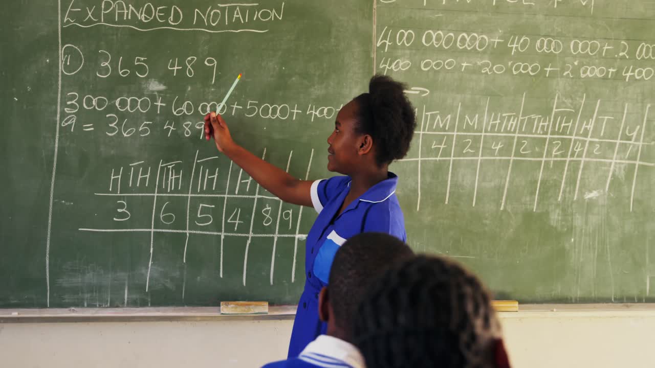 Young schoolgirl standing at the blackboard in class 4k