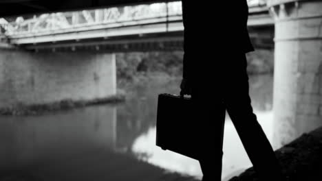 businessman walking under a bridge