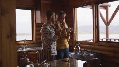 Caucasian-couple-spending-time-at-home-together,-drinking-a-beverage