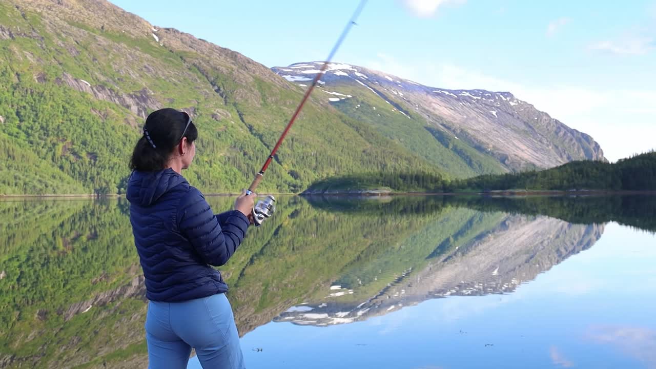 Wanita memancing dengan joran di Norwegia.