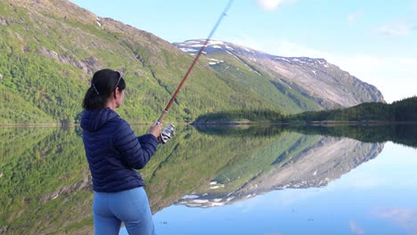 Woman-fishing-on-Fishing-rod-spinning-in-Norway.