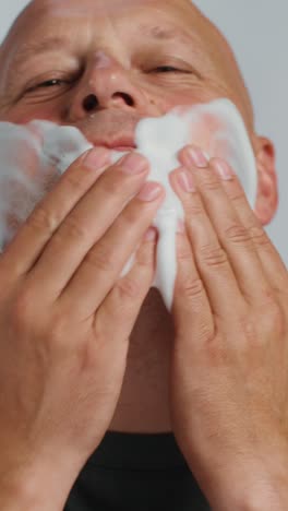 man washing his face with facial cleanser