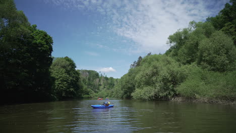 tired kayaker having a rest on river in kayak, beautiful nature around, sazava river, czech republic