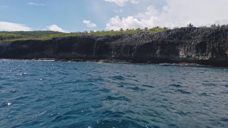 Sightseeing-on-boat-with-cliffs-in-background,-Las-Galeras-in-Dominican-Republic