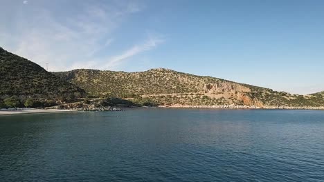 Flying-in-low-altitude-over-the-sea-at-first-and-then-higher-while-on-the-left-there-is-a-part-of-the-eastern-region-of-the-Peloponnese-coastline,-in-Greece