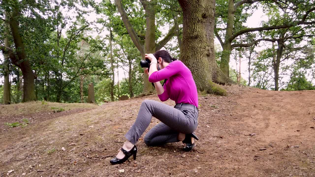 dama fotógrafa tomando fotos en el bosque